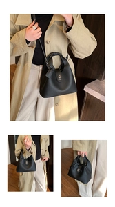 Detail of black pebbled leather bucket bag featuring a silver twist lock and shoulder strap