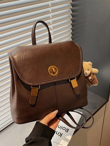 Vintage dark brown faux leather backpack with gold clasp and teddy bear charm