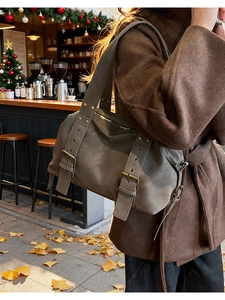 Macro detail of a vintage grey-green tote bag featuring metal rivets and rustic buckles