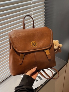 Vintage brown leather backpack with metal twist lock and cute teddy bear charm