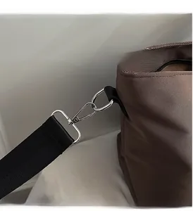 Polished silver hardware and durable strap detail on the large brown tote bag