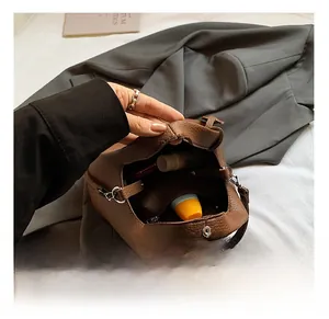 Interior view of brown pebble leather bucket bag showing capacity and magnetic closure