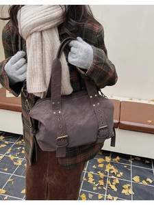 Detail view of charcoal grey vintage Boston bag with brass studs and buckle on street