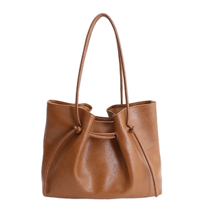 Minimalist caramel brown large tote bag in glossy leather texture with drawstring detail