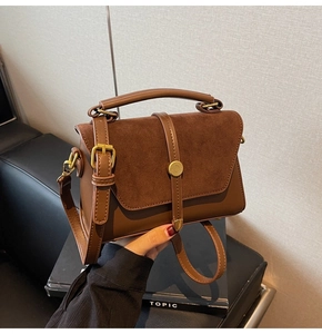 Detail showing vintage brown crossbody bag with mixed textures and gold hardware
