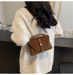 Close-up of brown vintage crossbody bag with suede拼接 and gold metal buckle detail
