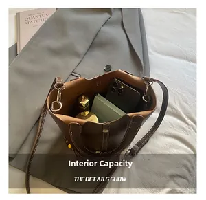 Top view of deep brown leather bucket bag showing spacious interior with personal items