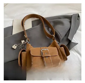 Detail of vintage brown leather bag with multi-pocket design and heart pendant