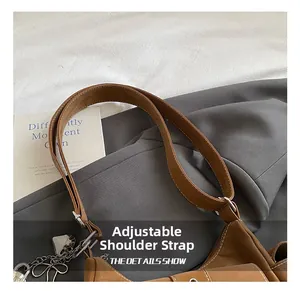 Detail showing the adjustable brown leather strap and silver heart-shaped chain charm