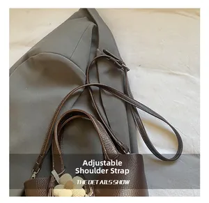 Detail of brown leather bucket bag with litchi texture and adjustable shoulder strap