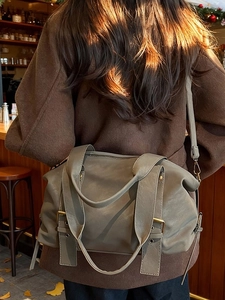 Chic khaki large capacity tote bag with rivets and adjustable strap in warm cafe setting