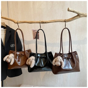 Trio de sacs cabas en cuir huilé avec breloques en peluche suspendus au décor rustique