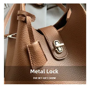 Detailed close-up of the silver metal lock on a brown pebble leather bucket bag