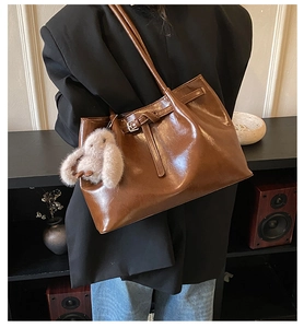 Détail du sac cabas vintage marron avec boucle décorative et breloque lapin en peluche