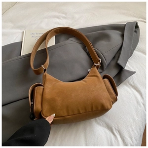 Detail of vintage brown shoulder bag featuring matte leather texture and large side pockets