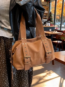 Brown vintage faux leather tote bag with eyelet strap in a sunlit autumn cafe setting