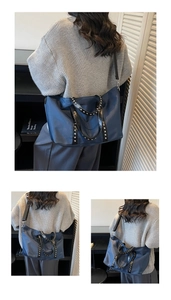 Detailed view of large navy tote bag featuring silver studs and leather straps