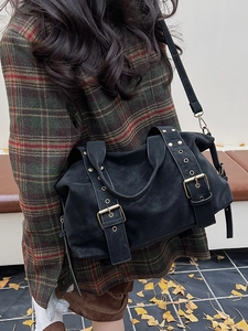 Retro black rivets tote bag with vintage buckled straps shown in an outdoor autumn setting