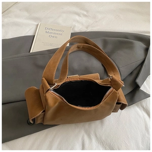 Detailed view of caramel brown leather shoulder bag with white contrast stitching detail