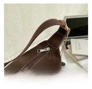 Detailed close-up of premium silver metal zipper and stitched leather shoulder strap