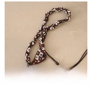 Detail of checkered woven strap with heart pattern for the stylish crossbody handbag
