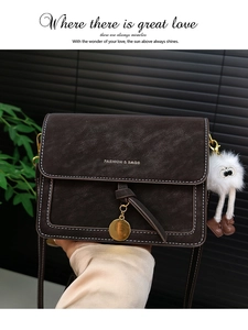 Detail of retro coffee leather bag with white contrast stitching and plush monster charm