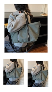 Macro shot of olive green tote bag featuring silver rivet details and black leather straps