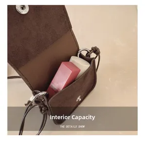 Detail showing internal capacity of the mini suede pouch with two lipsticks inside