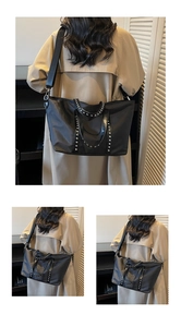 Detail of silver rivets and wide strap on large black vintage style tote bag