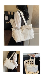 Detail view of cream tote bag with large bow decor and side drawstring pocket