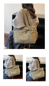 Detail of olive green canvas tote bag featuring a large decorative bow and wide shoulder strap