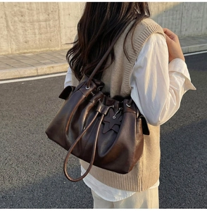Detail of dark brown drawstring bucket bag with star charm worn with a stylish outfit