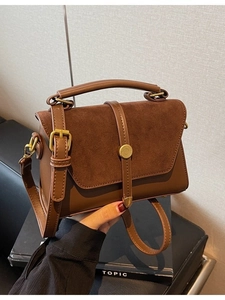 Minimalist brown matte leather tote bag with vintage metal clasp and shoulder strap