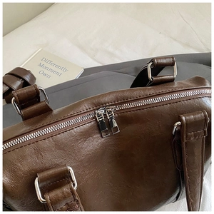 Detail view of dark coffee vintage tote bag with textured PU leather and silver zippers