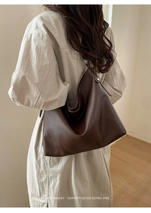 Gros plan d'un sac cabas en cuir marron foncé au style hobo rétro et design minimaliste