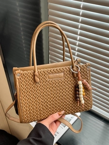 Vintage brown leather bucket bag with V-quilted texture and beaded pendant detail