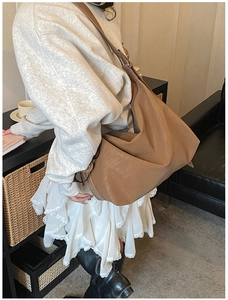 Brown suede hobo tote bag shown in a minimalist interior scene with soft natural light