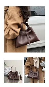 Detailed views of dark brown vintage leather bucket bag with ribbon decorative knot