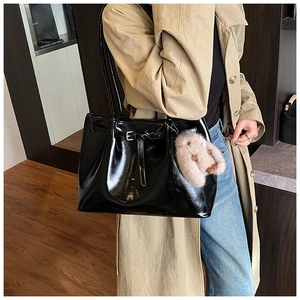 Sac fourre-tout en cuir verni noir brillant porté épaule avec charm lapin en peluche