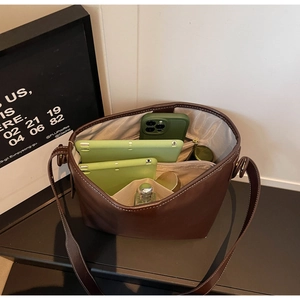 Detailed interior of brown leather bucket bag showing large capacity compartments