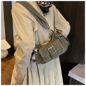 Detail of vintage olive green baguette bag featuring multi-pockets and silver heart charms