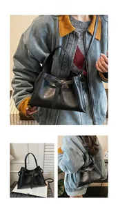 Detail view of black vintage tote bag with leather knot and adjustable strap