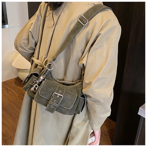 Close-up of olive green crossbody bag with multiple pockets and silver buckle hardware