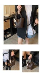 Macro detail of dark brown lychee leather bucket bag with metal buckle and flower charm