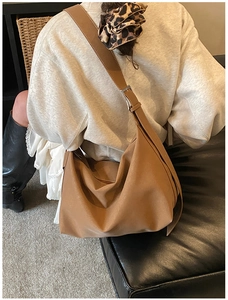 Close-up of caramel suede tote bag with wide strap and silver metal buckle detail