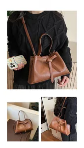 Detail of vintage brown PU leather tote bag featuring a unique tie-front knot design