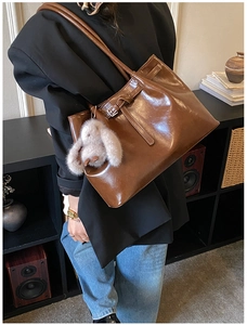 Détail du sac cabas vintage en daim marron avec cordon en cuir et breloque lapin en peluche