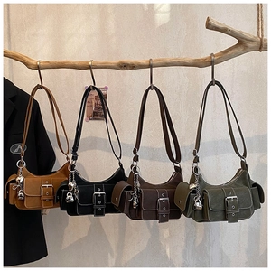 Retro-style satchels in four colors displayed on a branch against a textured wall