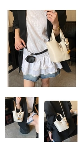 Macro detail of creamy white bucket bag with pebble leather texture and metal buckle