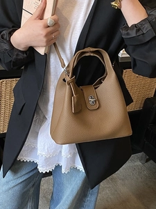 Chic brown pebbled leather tote bag with silver twist lock shown on model